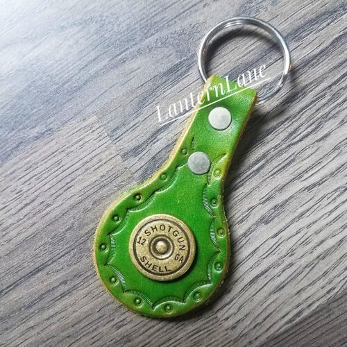 green key fob with shotgun shell casing end embedded